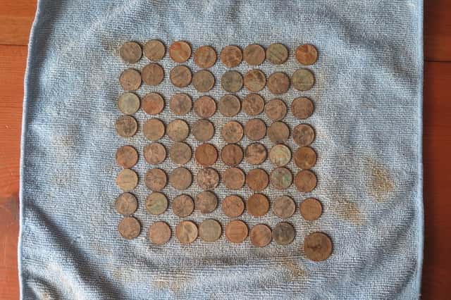 Pennies Arranged in a Grid with Dirt and Oxidation Resting on Blue Cloth
